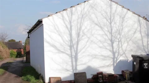 Silhouette Shadow of Tree Branches Gently Sway on White Garage on Country Lane Stock-Footage 49074686