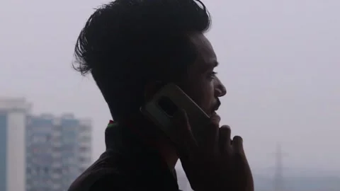 Silhouette short video of young man talking on the phone Stock Footage