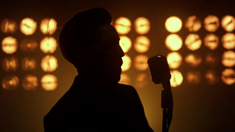 Silhouette singing man vocalist using microphone on show stage nightclub closeup Stock Footage 179026865