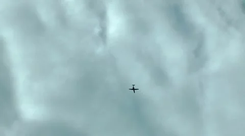 The silhouette of the small plane flies highly in the sky against clouds Stock-Footage 12314987