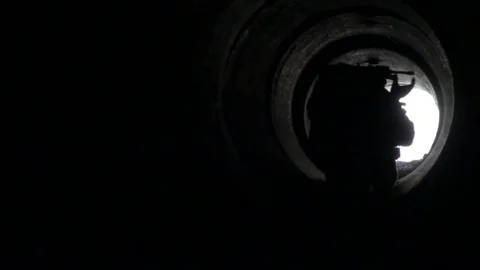 Silhouette of soldier crawling through tunner Video stock 76940311