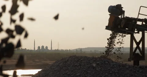 Silhouette of sorted rocks moving on conveyor line, falling into a pile Stock Footage 292305099