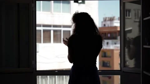 Silhouette of a spanish girl giving an applause during confinement Stock Footage