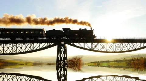 Silhouette of steam engine train crossing bridge road at sunset sky 库存影片 43558755