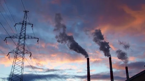 Silhouette of steel lattice tower, three chimneys smoke on dramatic sky Stock Footage