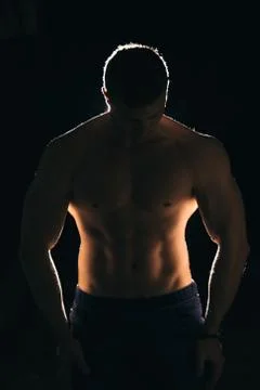 Silhouette of a strong man with dramatic light and dark background Stockfoto's