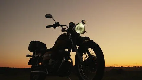 Silhouette at sunset of a motorcycle Stock Photos