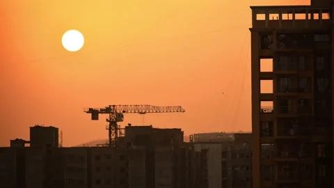 Silhouette sunset timelapse construction site workers working at building crane Stock Footage