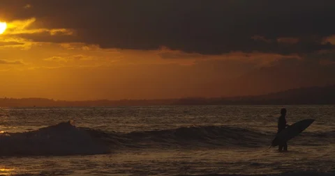 Silhouette surfer standing in waves during sunset at Ventura, California beach 库存影片 128668123