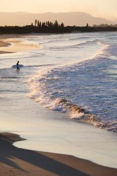Silhouette of surfer watching waves hitting shore on beach at Byron Bay in New Stock Photos
