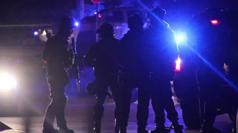 Silhouette of SWAT officers with riffles standing by police truck Stock Footage