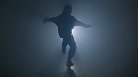 Silhouette of talented female dancer dancing hip hop in smoky studio in 4K, UHD Stock Footage 135083264