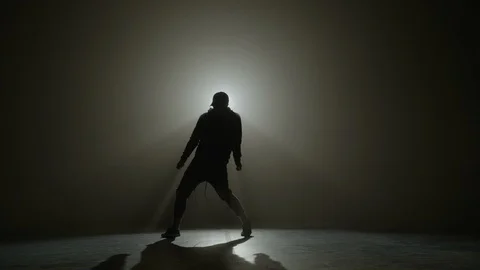 Silhouette of a talented young dancer dancing hip hop street dance on a stage Stock Footage 88632597