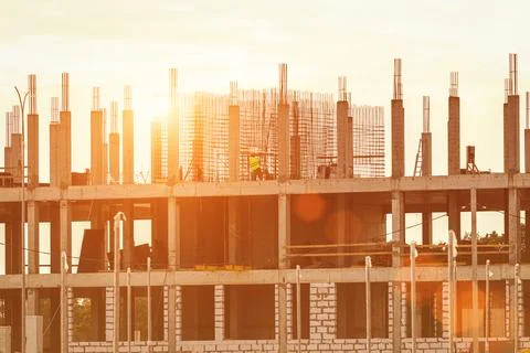 Silhouette of a team of construction workers constructing a building agains.. Stock Photos