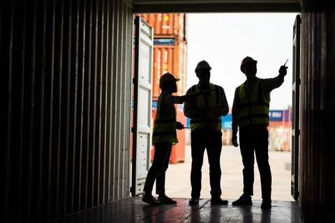 Silhouette of Team engineer dock control logistics worker wear safety helmets Stock Photos