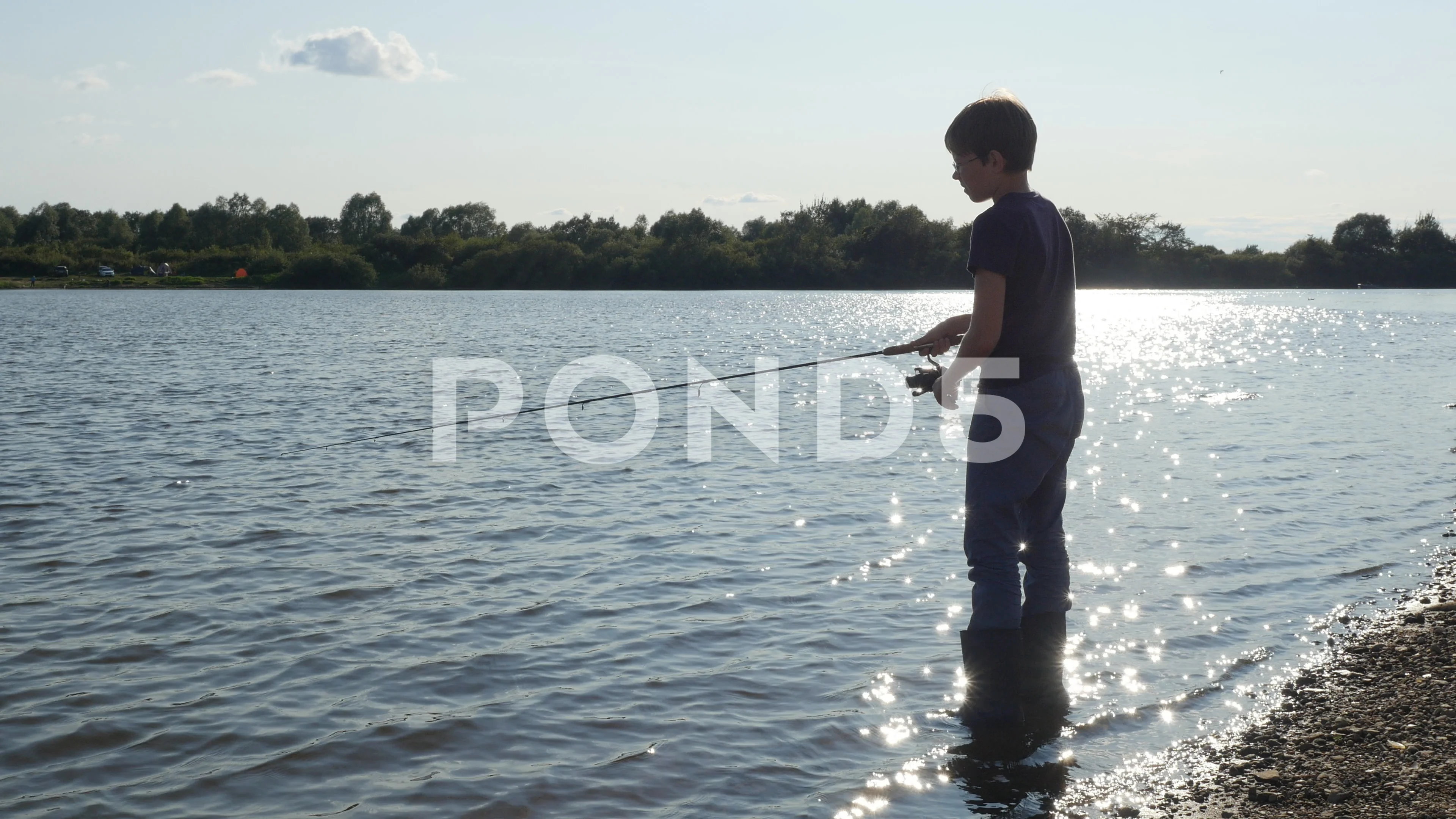 Silhouette of teen boy fishing with spin, Stock Video