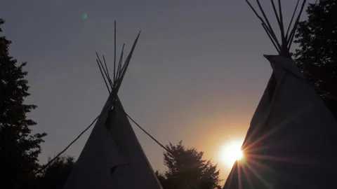Silhouette of teepee during sunset with sun flairs 2 Stock Footage 148015690