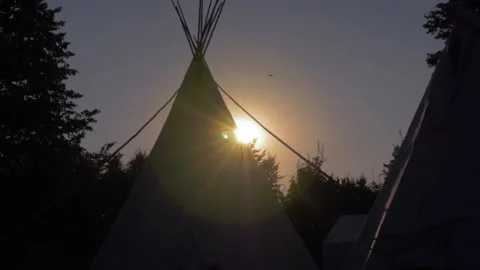 Silhouette of teepee during sunset with sun flairs Stock Footage 148016288