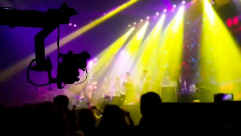 Silhouette of Television Camera hanging on crane in concert Stock Photos