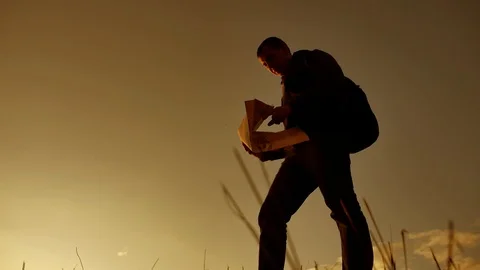 Silhouette of tourist man using map walks the trail of sun rise time tourist Stock-Footage 89586919