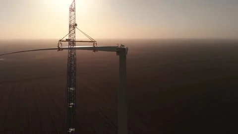 Silhouette of tower crane installing blade to wind turbine Stock Footage 149167116
