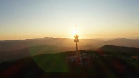Silhouette on tower structure high mountains lens flare aerial view drone turn Stock Footage 123545895
