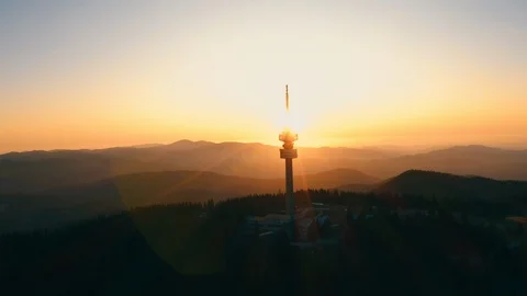 Silhouette on tower structure high mountains lens flare aerial view drone turn Stock Footage 123545952