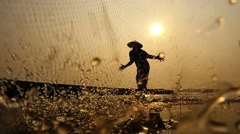 Silhouette Of Traditional Fishermen Throwing Net Fishing At