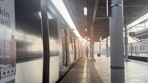 Silhouette of Train Driver Walking on Station Platform at Sunset in Bekasi Stock Footage 337522224