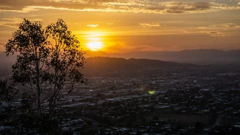 Silhouette of trees during sunset overlooking city, Townsville Australia Stock Photos