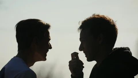 Silhouette of two cheerful friends that talking and laughing outdoors. One Stock Footage 105082007