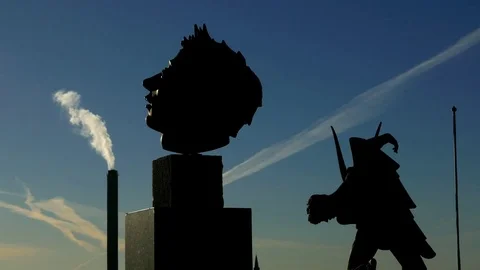 Silhouette of two different statues with factory smoke clouds in the background Stock Footage 75044571