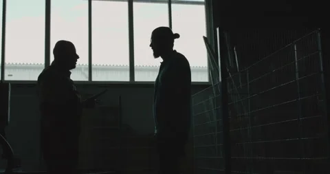 Silhouette of two engineers talking and shaking hands at industrial factory Video stock 130562885