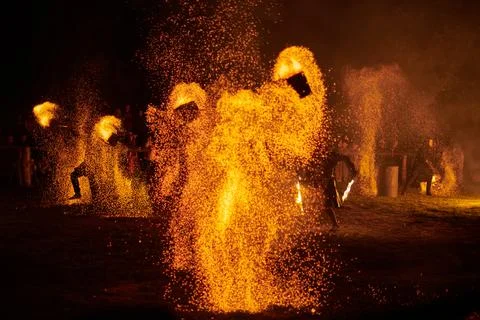 Silhouette of Two Fire Performers Creating Sparks Against Night field Stock Photos