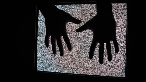 Silhouette of Two Hands Descending onto Static Television Stock Footage 307399150