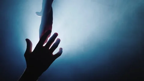 A silhouette of two people helping each other in a dark and foggy room with.. Vídeos de archivo 334641676