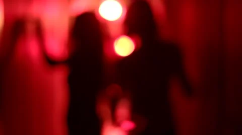 Silhouette of two sexy women dancing in a blurry, red corridor Stock Footage 59553228