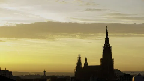 Silhouette of Ulm minster while dawn and sunrise with yellow sky time lapse Stock Footage 221264108