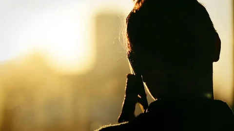Silhouette of unrecognizable woman using a smartphone in sunset light 스톡 동영상 73094237
