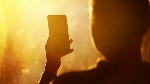 Silhouette of unrecognizable woman using a smartphone in sunset light Stock Footage 73094249