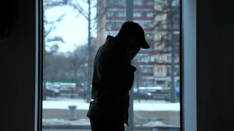 Silhouette of a upset man on the background of the window Stock Footage 151474068