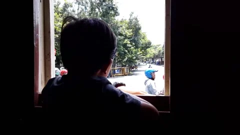 Silhouette video of a boy looking out the window while riding a train. Stock Footage 220383438