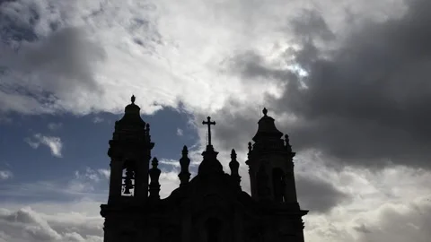 Silhouette view of clouds rushing behind a silhouette ancient gothic church Stock Footage 254781946