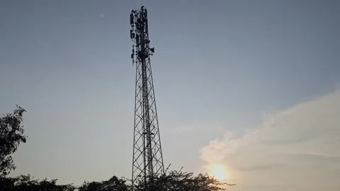 Silhouette view of phone tower against evening sky with fading light and ca.. Vídeos de archivo 336042653
