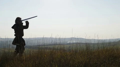 Silhouette of a Viking practicing using the sword for battle. Stock Footage 81351174
