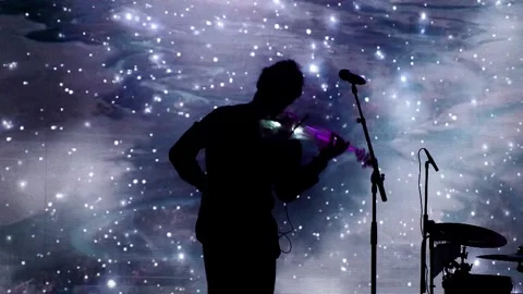 Silhouette of a violinist playing a glowing electronic violin. Vídeos de archivo 302091663