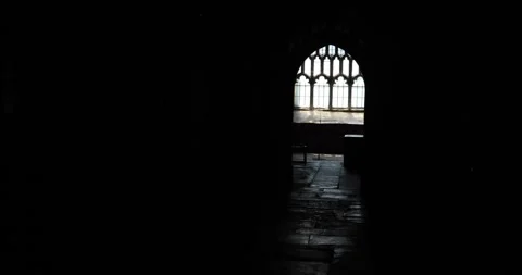 Silhouette walking past gothic window inside a dark medieval church Stock Footage 319769951
