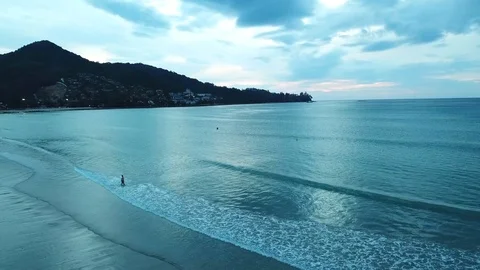 Silhouette walks on the beach at sunset 스톡 동영상 88163155