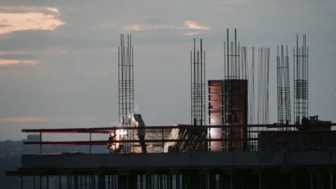 Silhouette of welders working on building construction site at sunset Stock Footage 346046924