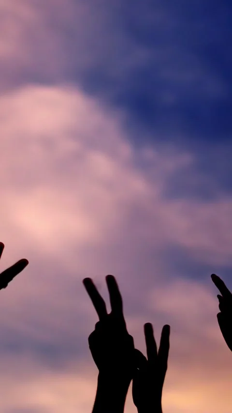 Silhouette on white of hands gesturing victory with sunset background Stock Footage 265755292